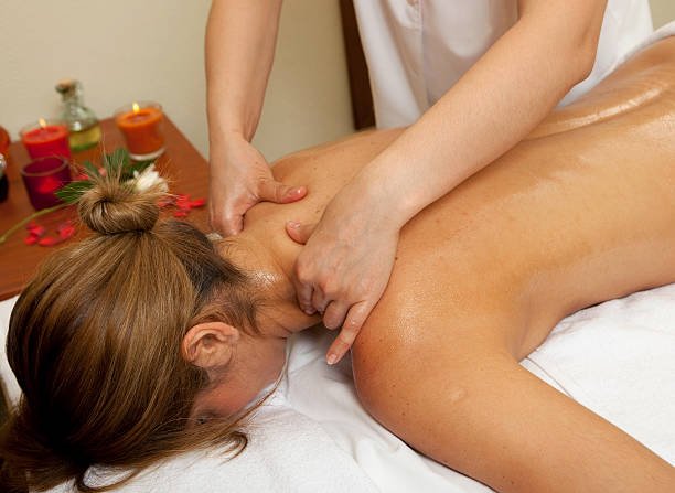 Close-up of hands applying deep tissue massage on a client’s shoulders
